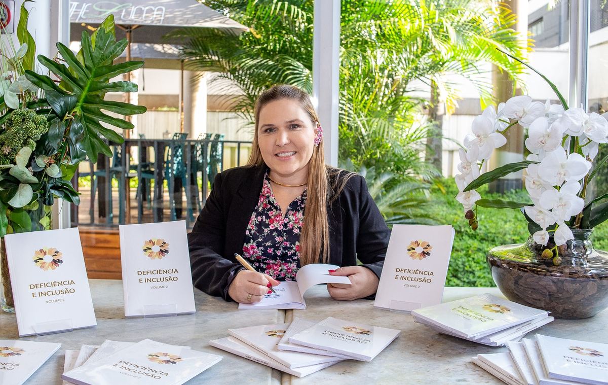 A Dra. Priscilla Machado autografando exemplares do livro Deficiência e Inclusão, Volume 2